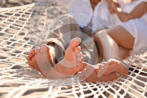 Couple relaxing in hammock on beach, closeup