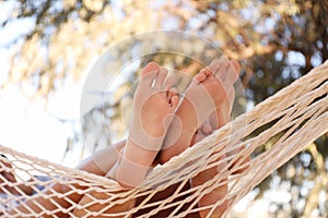 Couple relaxing in hammock outdoors on sunny day, closeup. Summer vacation