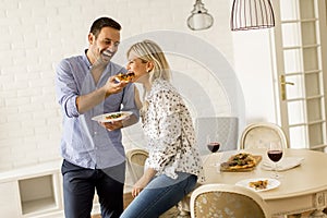 Couple relaxing at home and eating tasteful pizza