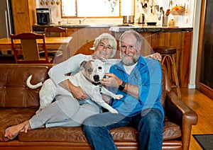 Couple relaxing at home and loving their pet. Positive image of life at home and New Normal