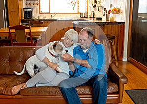 Couple relaxing at home and loving their pet. Positive image of life at home and New Normal