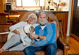 Couple relaxing at home and loving their pet. Positive image of life at home and New Normal