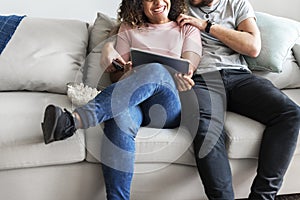 Couple relaxing at home using digital device
