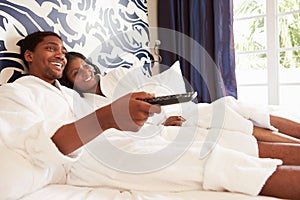 Couple Relaxing In Hotel Room Watching Television