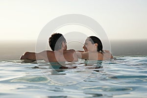 Couple Relaxing In Infinity Pool At Resort