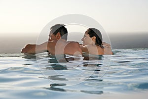 Couple Relaxing In Infinity Pool At Resort