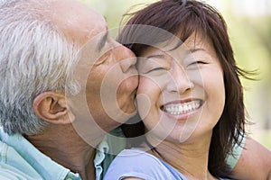 Couple relaxing outdoors in park kissing