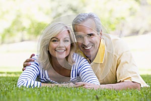 Couple relaxing outdoors in park smiling