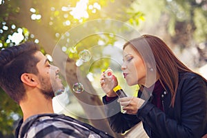 Couple Relaxing in the Park with bubble blower. Spring time.