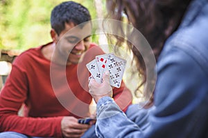 Couple relaxing and playing cards together in spring garden, closeup