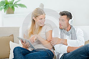 Couple relaxing on sofa with gadgets