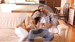 Couple relaxing on sofa and having coffee