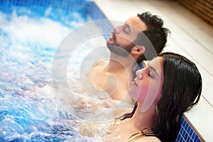 Couple relaxing in spa jacuzzi.