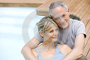 Couple Relaxing By Swimming Pool