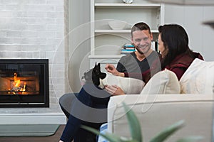 Couple relaxing with their pet dog in living room