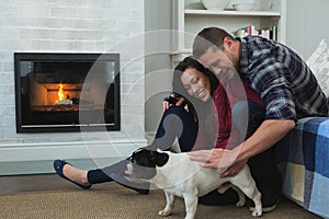 Couple relaxing with their pet dog in living room