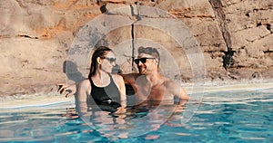 couple relaxing together in spa swimming pool. romantic getaway