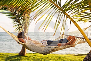 Couple relaxing in tropical hammock