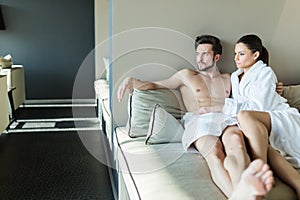 Couple relaxing at a wellness center, laying in a rob and towel
