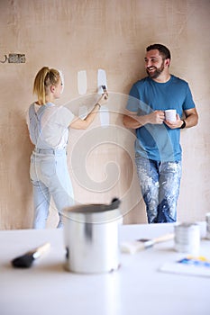 Couple Renovating Kitchen At Home Painting Tester Paint Colour Strips On Wall
