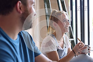 Couple Renovating Kitchen At Home Sitting On Floor Taking A Break From Decorating Kitchen