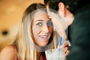 Couple in restaurant drinking milkshake