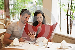Couple, restaurant and menu for choice, conversation and bonding on valentines day. People, love and romance at cafe or