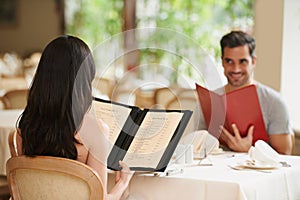 Couple, restaurant and menu for food choice, fine dining and bonding on valentines day. People, love and romance at cafe