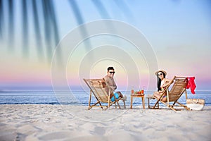 Couple resting on beach at resort