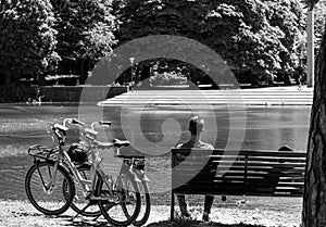 A couple resting at a bench on Sweden national day after going to the park by using a rental bike from Donkey Republic