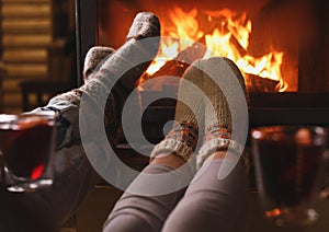 Couple resting near fireplace indoors. Winter vacation