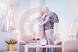 Couple of retired man and woman having extremely romantic date at home