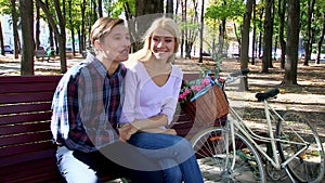 Couple with retro bike in the park on bench