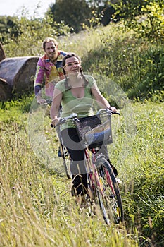 Couple riding bikes in countryside