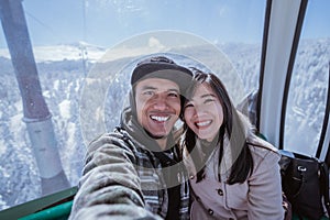 couple riding a cable car in the beautiful snowy mountain in turkey