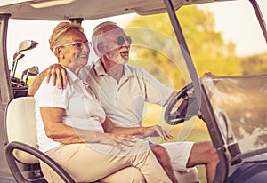 Couple are riding in a golf cart and talking