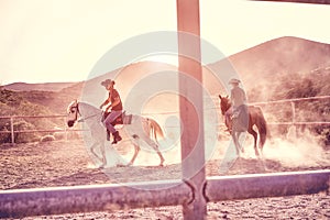 Couple riding horses inside corral ranch - Happy people having fun on summer day - Vacation, excursion, healthy lifestyle, sport,