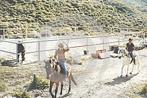 Couple riding horses starting from ranch for excursion day - Happy people having fun on summer time into the wild - Tour,