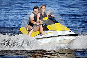 Couple riding jet ski