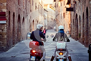 Couple riding motor scooter on city.Bikers on the road