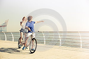 Couple riding on tandem bicycle outdoors