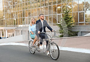 Couple riding tandem bike