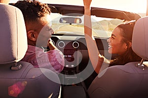 Couple On Road Trip Driving In Convertible Car