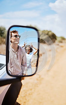 Couple on road trip, smile in car mirror reflection and happy smile with love on desert holiday road trip drive in South