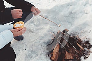 Couple roast marshmallow over campfire