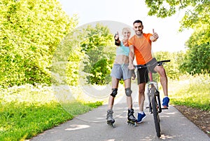 Couple on rollerblades and bike showing thumbs up