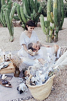 Couple on romantic date lay on picnic blanket