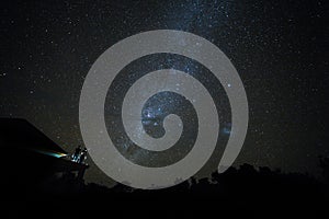 Couple on rooftop watching mliky way and stars in the night sky on Bali island