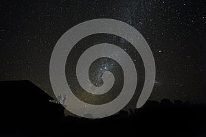 Couple on rooftop watching mliky way and stars in the night sky on Bali island