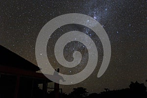 Couple on rooftop watching mliky way and stars in the night sky on Bali island